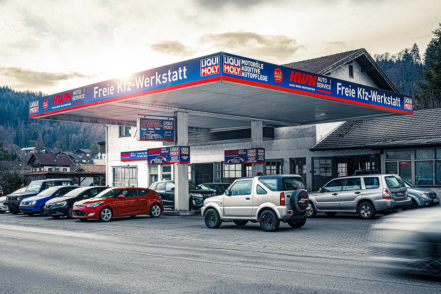 Außenansicht der freien HWM Kfz-Werkstatt in Kiefersfelden mit mehreren Fahrzeugen