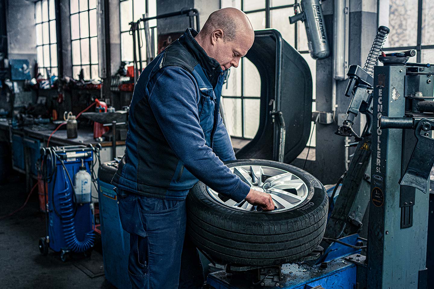 Mechaniker montiert Reifen auf Felge in der Werkstatt