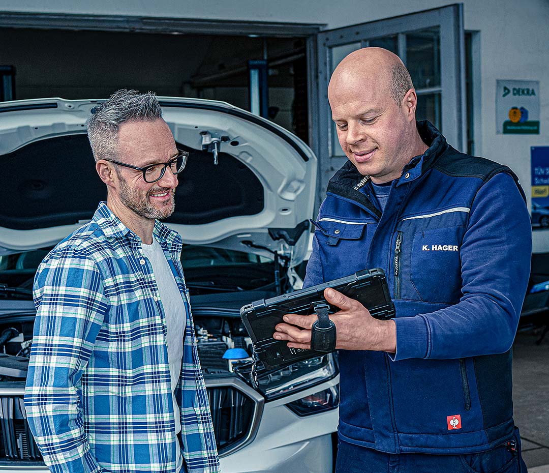 Kfz-Meister Hager erklärt einem Kunden verständlich den Befund am Fahrzeug